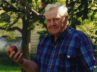 A Man in a Blue and Black Color Shirt Holding an Apple