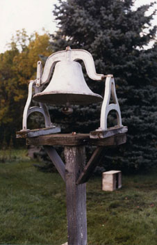 A Wooden Post With a White Color Bell