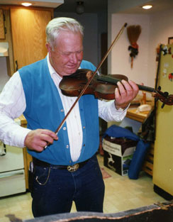 A Man With a Blue Vest Playing a Violine