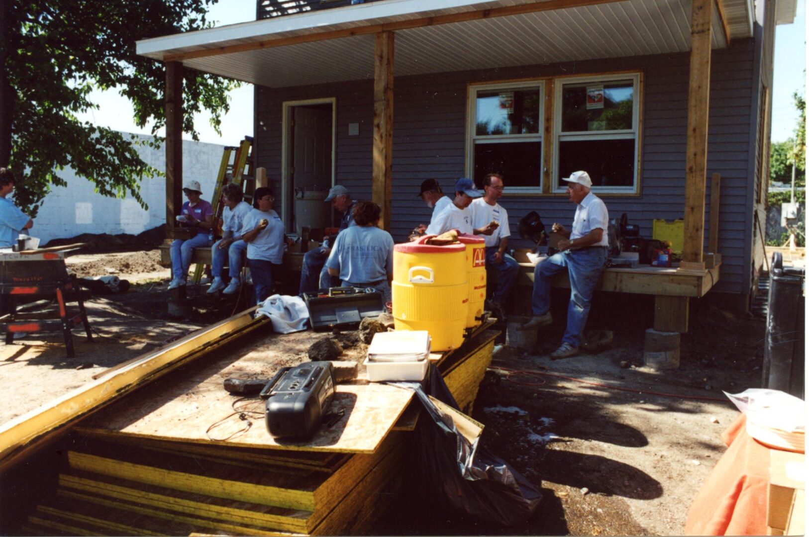 Group of men and women sitting under a house shelter